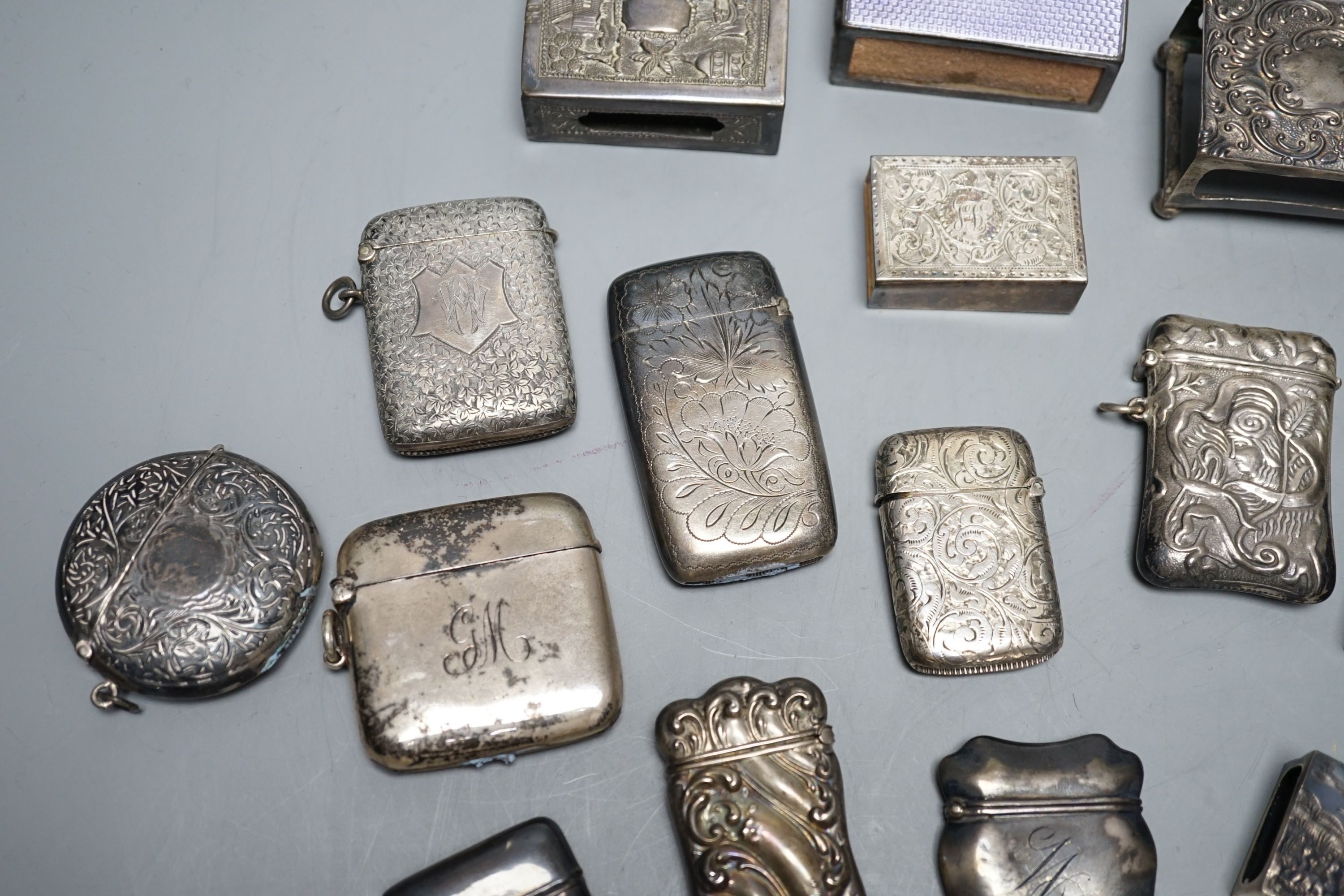 A small collection of nine mainly early 20th century silver or sterling vesta cases, largest 60mm and fourteen assorted similar silver or white metal match sleeves